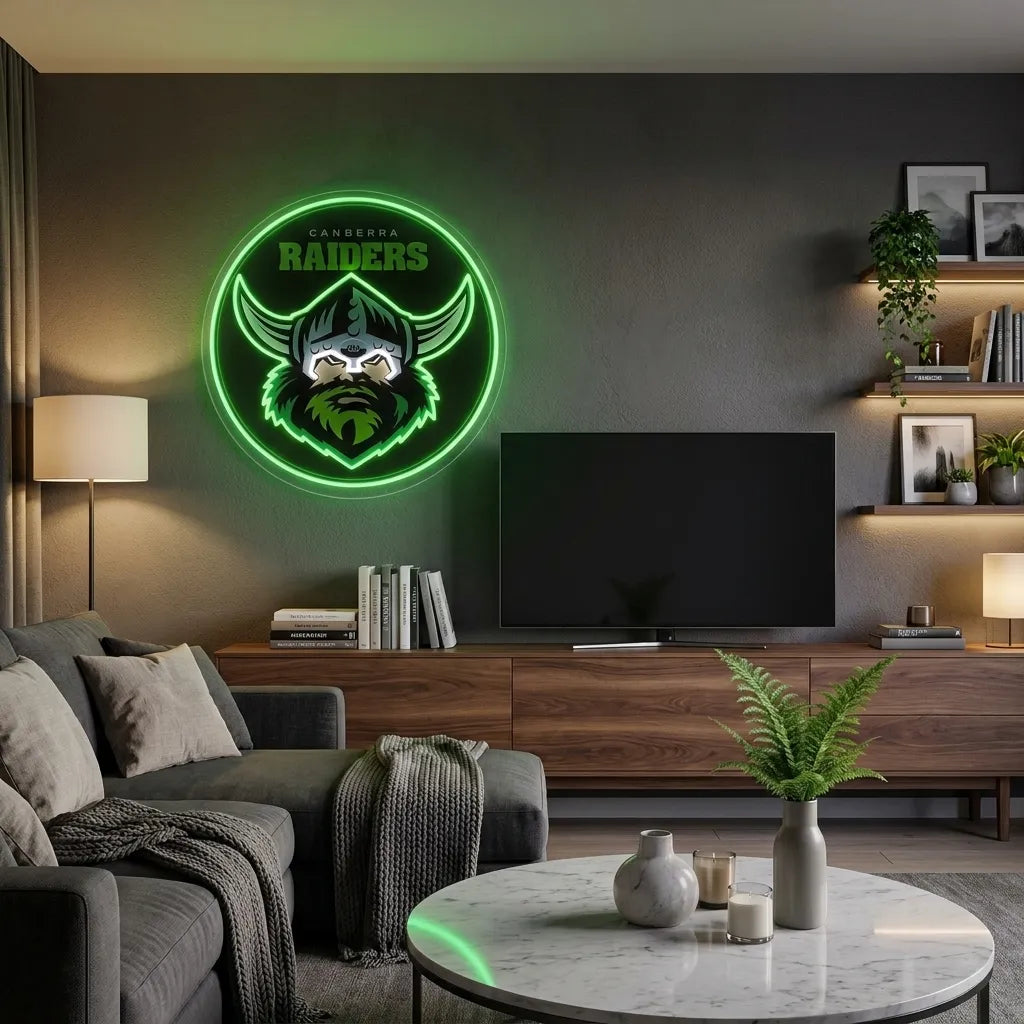 A circular green neon-style wall sign featuring a Viking helmet and the word 'Raiders' mounted above a TV in a modern living room.